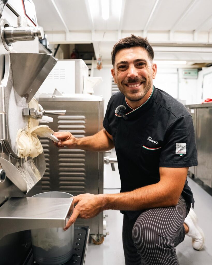 Edoardo Gori en tenue de glacier, spatule à la main, devant la turbine à glace de son laboratoire Ughissimo à Bayonne
