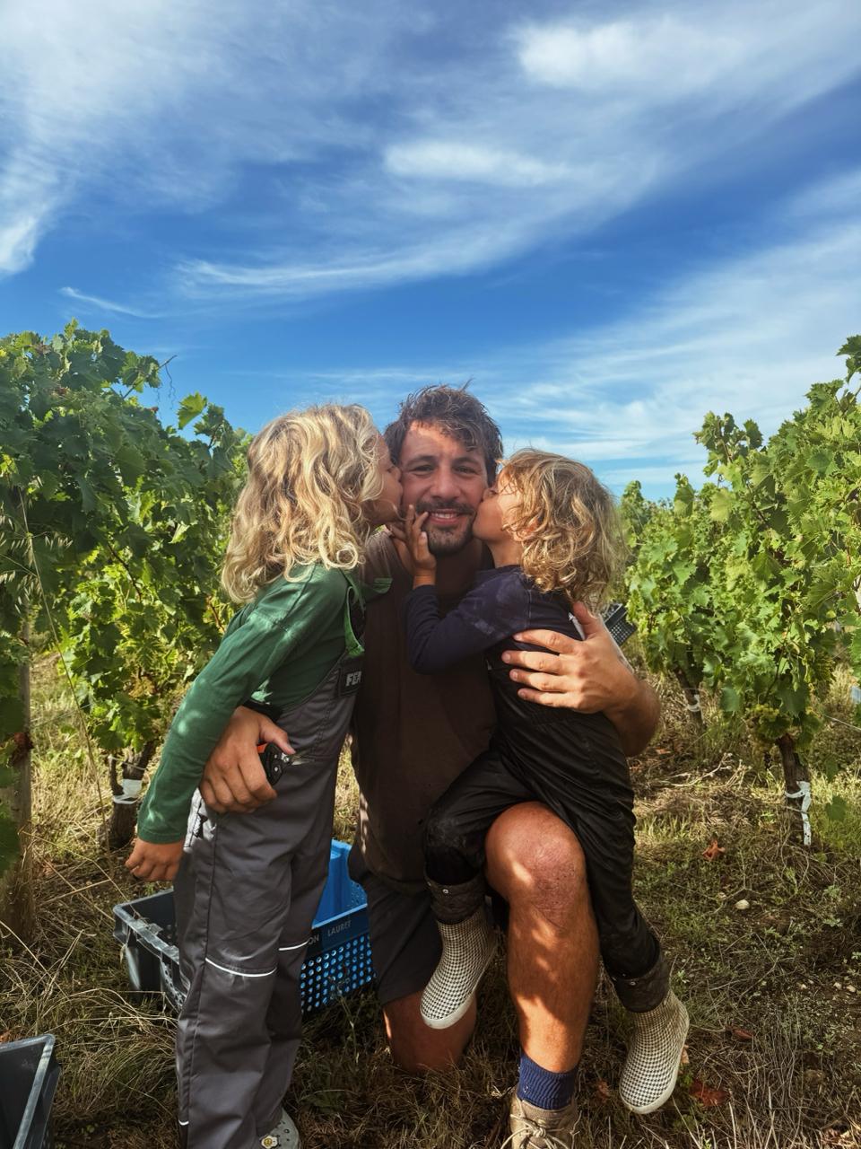 Rémi Lamerat dans ses vignes, embrassé par ses deux enfants